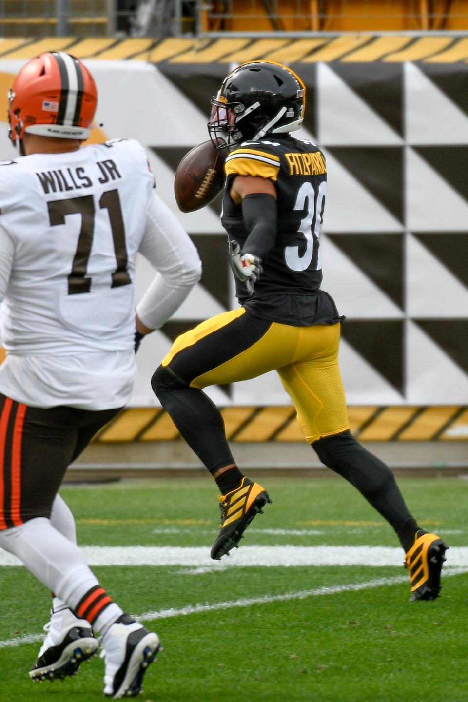 Pittsburgh Steelers free safety Minkah Fitzpatrick (39) heads to the end zone and a touchdown past Cleveland Browns offensive tackle Jedrick Wills (71) after intercepting a Baker Mayfield pass during the first half of an NFL football game, Sunday, Oct. 18, 2020, in Pittsburgh. (AP Photo/Don Wright)