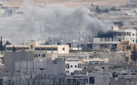 Smoke rises over Syrian town of Kobani, as seen from the Mursitpinar crossing on the Turkish-Syrian border, October 26, 2014. REUTERS/Kai Pfaffenbach