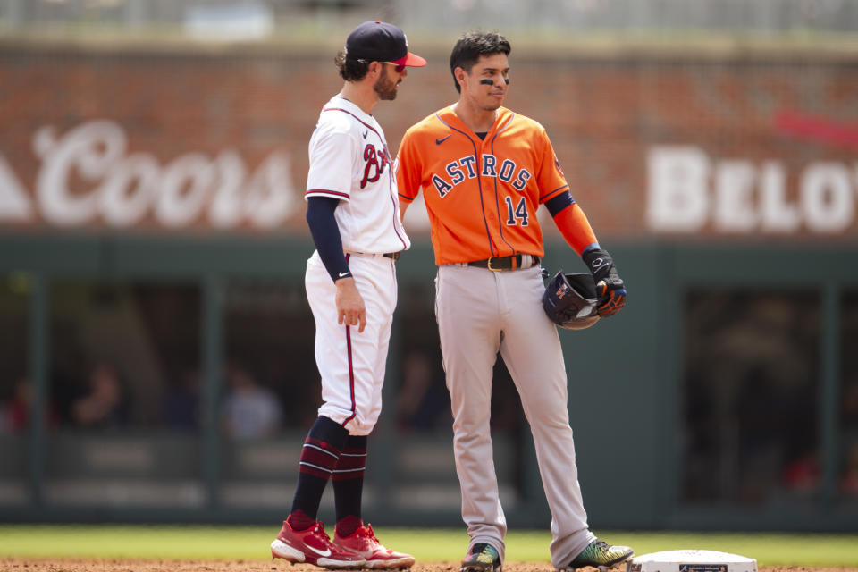 Atlanta Braves shortstop Dansby Swanson, left, speaks to Houston Astros' Mauricio Dubon, right, during the third inning of a baseball game Sunday, Aug. 21, 2022, in Atlanta. (AP Photo/Hakim Wright Sr.)