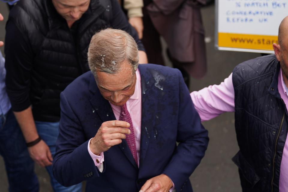 Leader of Reform UK Nigel Farage has a drink thrown over him as he leaves the Moon and Starfish pub after launching his General Election campaign in Clacton-on-Sea, Essex. Picture date: Tuesday June 4, 2024.