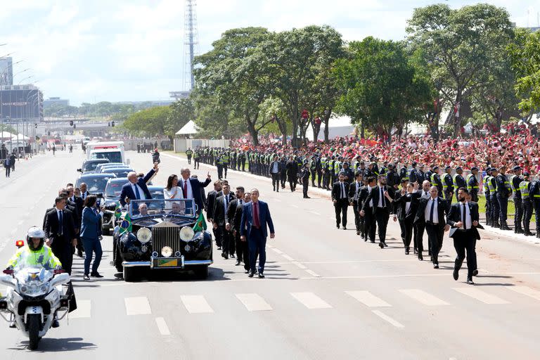 President-elect Luiz Inacio Lula da Silva, left, Vice President-elect Geraldo Alckmin, center right, and his wife Maria Lucia Ribeiro, ride on an open car to Congress for their swearing-in ceremony, in Brasilia, Brazil, Sunday, Jan. 1, 2023. (AP Photo/Andre Penner)