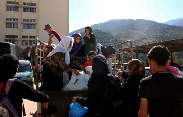 Syrian refugees gather their belongings in the southern Lebanese village of Shebaa as they prepare to return to Syria on August 13, 2018