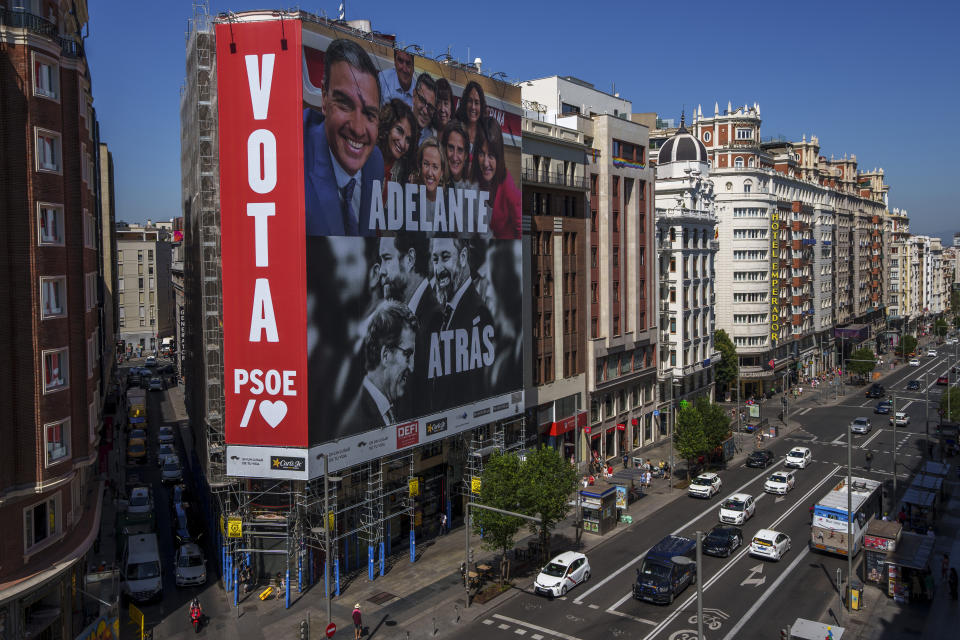 Un gigantesco cartel electoral muestra al presidente del gobierno español y candidato del Partido Socialista, Pedro Sánchez, arriba, y al líder del conservador Partido Popular, Albert Núñez Feijóo, y del grupo de ultraderecha Vox, Santiago Abascal, en un edificio de la Gran Vía de Madrid, España, el 10 de julio de 2023. (AP Foto/Manu Fernández)