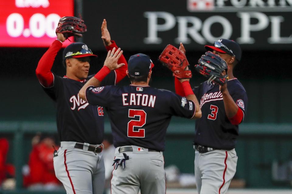 El dominicano Juan Soto, Adam Eaton y Michael A. Taylor (3), de los Nacionales de Washington, festejan la victoria en el segundo juego de la Serie de Campeonato de la Liga Nacional ante los Cardenales de San Luis, el sábado 12 de octubre de 2019 (AP Foto/Jeff Roberson)