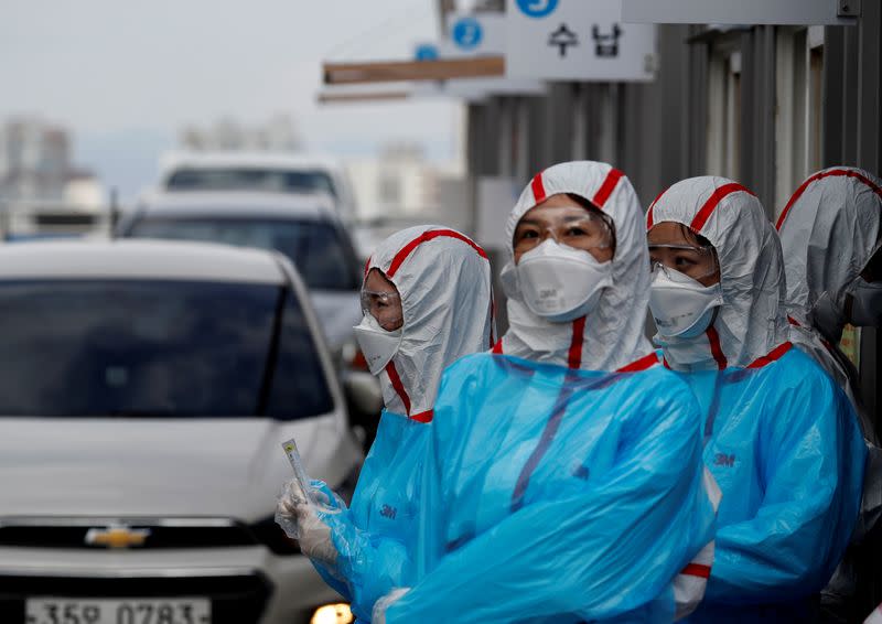 FILE PHOTO: Medical staff in protective gear work at a 'drive-thru' testing center for the novel coronavirus disease of COVID-19 in Yeungnam University Medical Center in Daegu