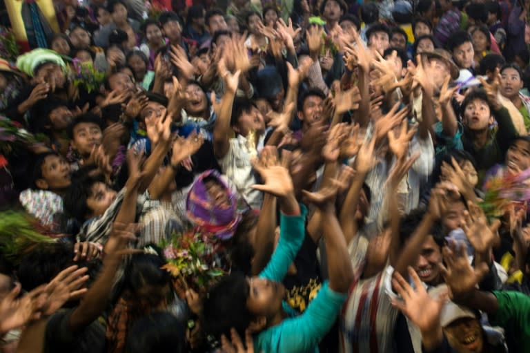 Devotees scramble to grab money thrown into the crowd by wealthy participants inside a shrine during the Ko Gyi Kyaw Nat festival