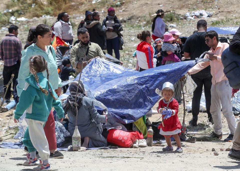 A family attempts to make a makeshift shelter near the border fence at Monument Rd. close to the International Wastewater Treatment Plant in San Diego, Calif., May 11, 2023. 