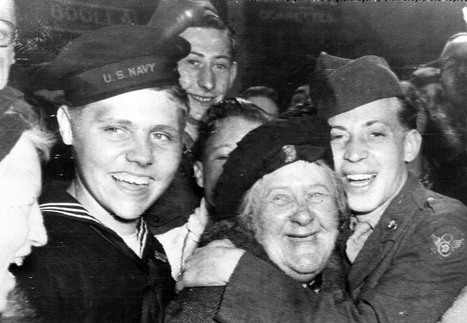 FILE - In this May 7, 1945 file photo an American soldier, right, hugs a British woman as other U.S. servicemen celebrate the surrender of Germany in London's Piccadilly Circus. Nazi commanders signed their surrender to Allied forces in a French schoolhouse 75 years ago this week, ending World War II in Europe and the Holocaust. Unlike the mass street celebrations that greeted this momentous news in 1945, surviving veterans are marking V-E Day this year in virus confinement, sharing memories with loved ones, instead of in the company of comrades on public parade. (AP Photo, File)
