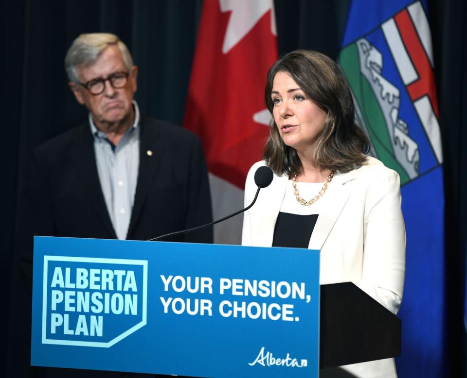 Jim Dinning watches as Premier Danielle Smith speaks at the Sept. 21 release of a report about an Alberta pension plan. Dinning, a former provincial finance minister, led a panel that held a series of of telephone town halls across Alberta to gauge support for the proposed plan. (Chris Schwarz/Government of Alberta - image credit)