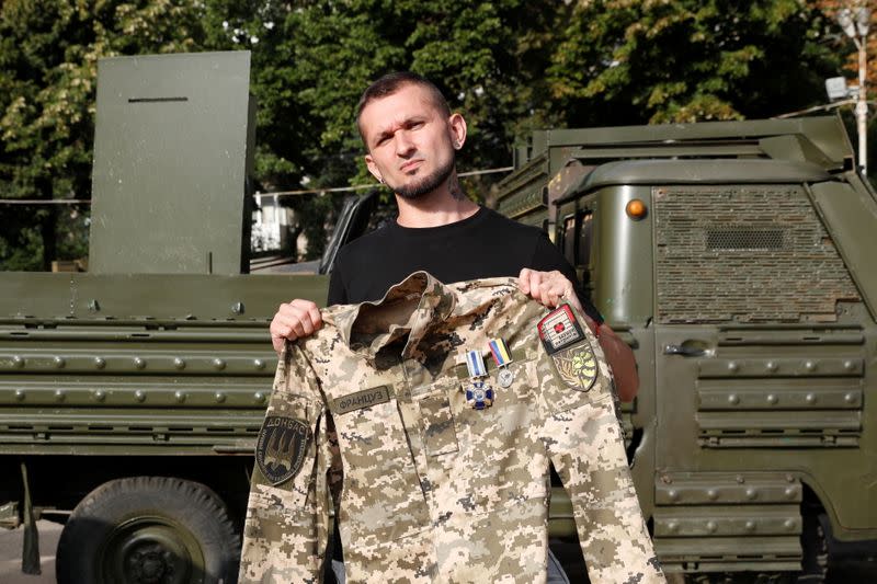 Ukrainian war veteran Viktor Pylypenko poses for a picture with his military uniform in Kyiv