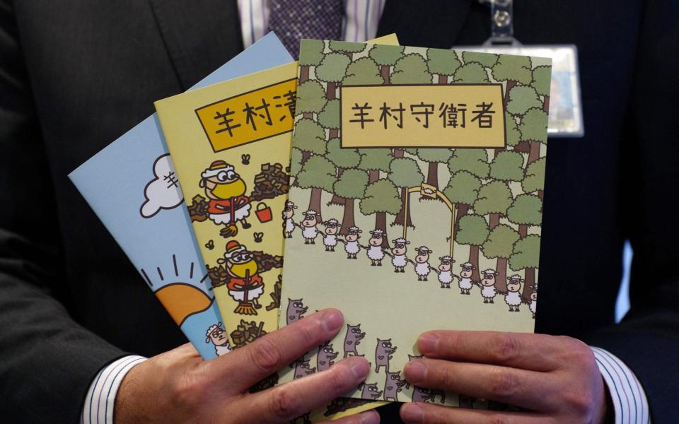 Hong Kong's senior superintendent Steve Li, from the city's new national security police unit, holds children's books which allegedly try to explain about the city's democracy movement, at a police press conference in Hong Kong on July 22, 2021, after five members of a pro-democracy Hong Kong union were arrested for sedition for publishing the titles. - AFP