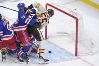 Boston Bruins right wing Justin Brazeau (55) hits the puck into the net to score as New York Rangers defenseman K'Andre Miller (79) defends in the third period of an NHL hockey game, Thursday, March 21, 2024, in Boston. (AP Photo/Steven Senne)