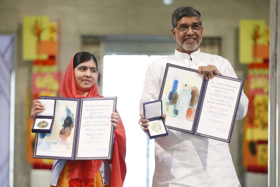 Nobel Peace Prize laureates Malala Yousafzai and Kailash Satyarthi (R) pose with their medals during the Nobel Peace Prize awards ceremony at the City Hall in Oslo December 10, 2014. Pakistani teenager Malala Yousafzai, shot by the Taliban for refusing to quit school, and Indian activist Kailash Satyarthi received their Nobel Peace Prizes on Wednesday after two days of celebration honouring their work for children's rights. REUTERS/Cornelius Poppe/NTB Scanpix/Pool (NORWAY - Tags: SOCIETY CIVIL UNREST) NORWAY OUT. NO COMMERCIAL OR EDITORIAL SALES IN NORWAY.