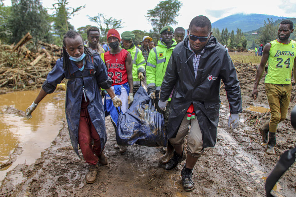 Kenya Red Cross workers and volunteers, carry a man's body retrieved from mud, after floodwater washed away houses, in Kamuchiri Village Mai Mahiu, Nakuru County, Kenya, Tuesday, April 30, 2024. Kenya, along with other parts of East Africa, has been overwhelmed by flooding that killed 66 people on Monday alone and in recent days has blocked a national highway, swamped the main airport and swept a bus off a bridge. More than 150,000 people are displaced and living in dozens of camps. (AP Photo/Patrick Ngugi)