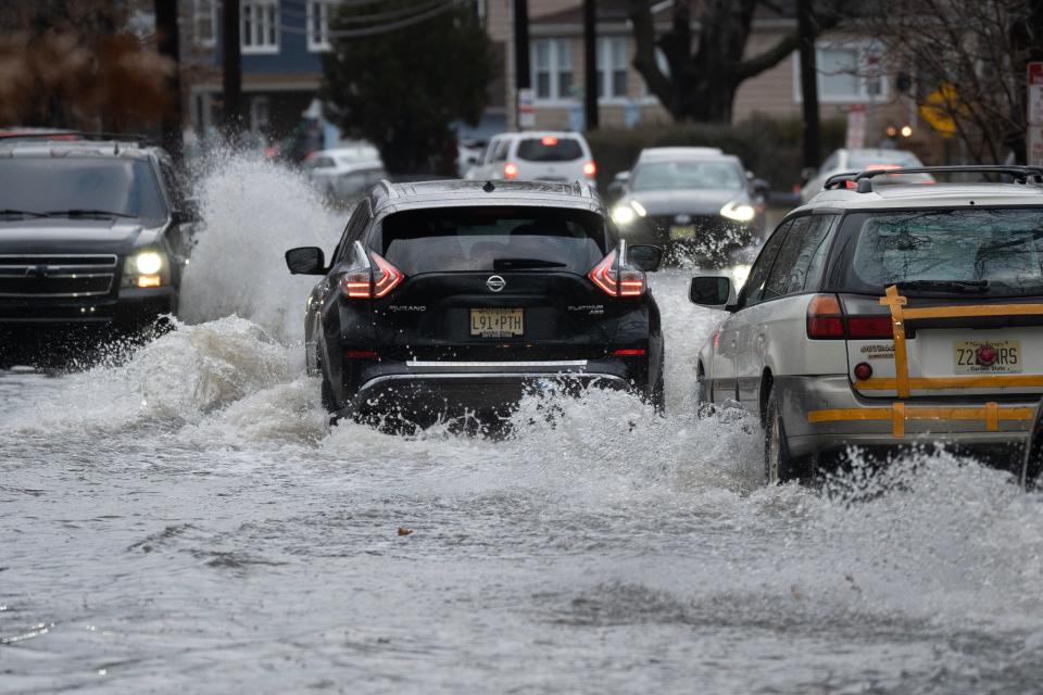 Cars slowly make their way through high water along Bergen Turnpike in Ridgefield Park, N.J. on Friday Dec. 23, 2022. 
