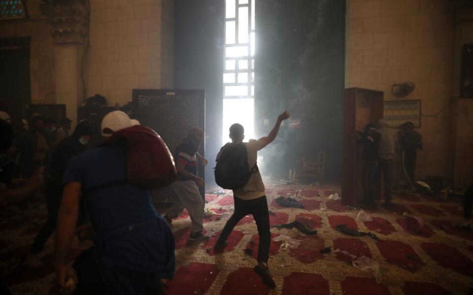 Palestinians inside the Al-Aqsa mosque clash with Israeli security forces at the Al Aqsa Mosque compound in Jerusalem's Old City Monday, May 10, 2021 - Mahmoud Illean /AP