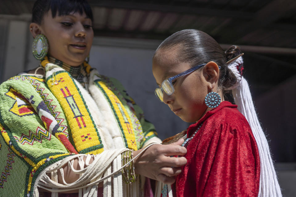 Shantal Sandoval, left, and her eight year-old daughter Chanel Yazzie, of To'hajiilee, N.M., prepare to participate in a horse parade at the 40th anniversary of the Gathering of Nations Pow Wow in Albuquerque, N.M., Friday, April 28, 2023. Tens of thousands of people gathered in New Mexico on Friday for what organizers bill as the largest powwow in North America. (AP Photo/Roberto E. Rosales)