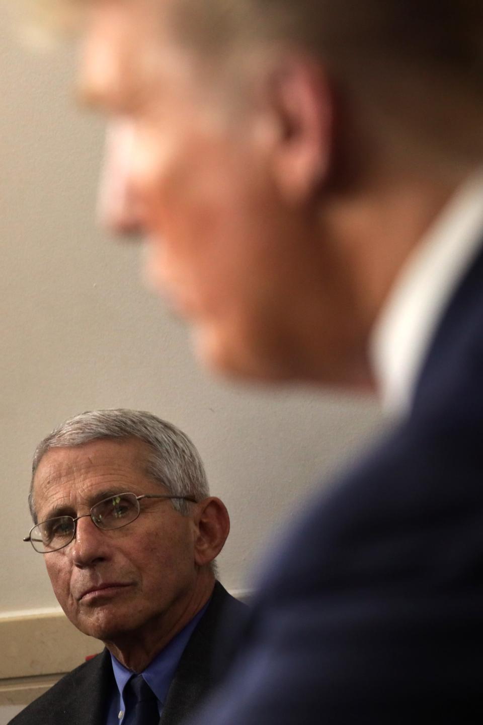 Fauci looks on as Trump addresses the press in the White House on April 13, 2020.