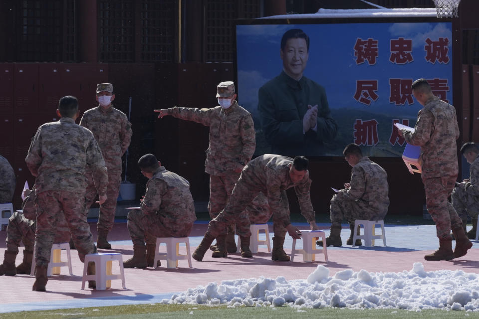 Military personnel take part in studies outdoors near a photo of President Xi Jinping on Saturday, March 19, 2022, in Beijing. China's national health authorities reported two COVID-19 deaths on Saturday, the first recorded rise in the death toll since January 2021, as the country battles an omicron-driven surge. (AP Photo/Ng Han Guan)