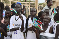 South Sudanese hold flags as they wait to welcome back the country's basketball team, at Juba International airport, South Sudan, Tuesday, Sept.5, 2023. Basketball has united the South Sudanese. The country which gained its independence just 12 years ago is still celebrating the men’s national team after its first-ever qualification for the Olympics. South Sudan will play at the Paris Olympics as the automatic qualifier from Africa thanks to a 101-78 win over Angola a week ago at the basketball World Cup in the Philippines.(AP Photo /Samir Bol)