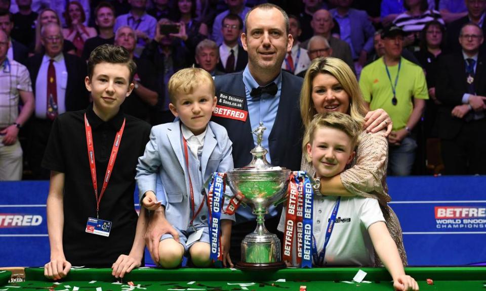 Mark Williams celebrates with the trophy and his family after winning his third World Snooker Championship title 15 years after his second.