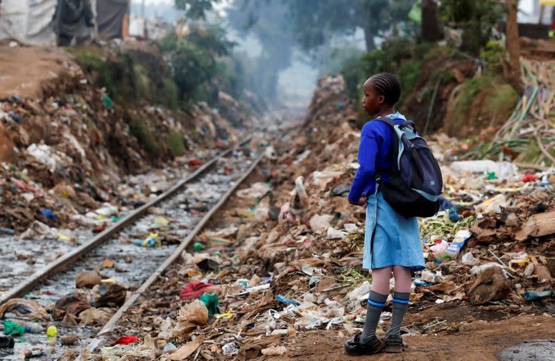 A schoolgirl stands next to the Kenya-Uganda railway line during the partial reopening of schools, in Nairobi