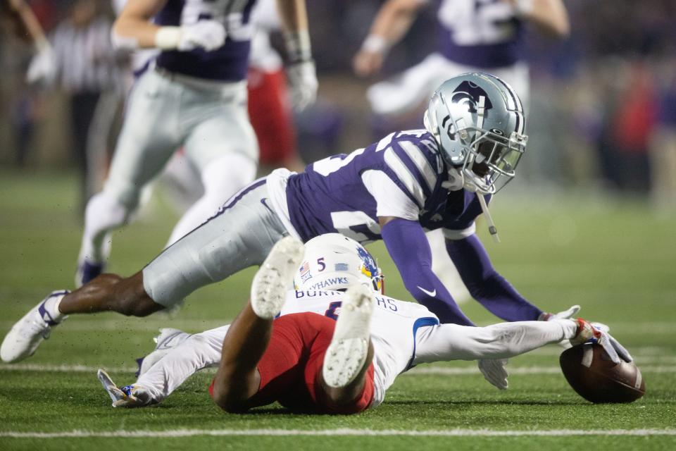 Kansas sophomore safety O.J. Burroughs (5) drops a kickoff return as Kansas State senior cornerback Ekow Boye-Doe (25) lunges for a turnover during the first quarter of Saturday’s Sunflower Showdown at Bill Snyder Family Stadium.<br>© Evert Nelson/The Capital-Journal / USA TODAY NETWORK