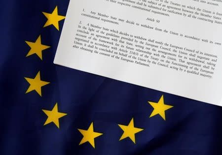 Article 50 of the EU's Lisbon Treaty that deals with the mechanism for departure is pictured with an EU flag following Britain's referendum results to leave the European Union, in this photo illustration taken in Brussels, Belgium, June 24, 2016. REUTERS/Francois Lenoir/Illustration/File Photo