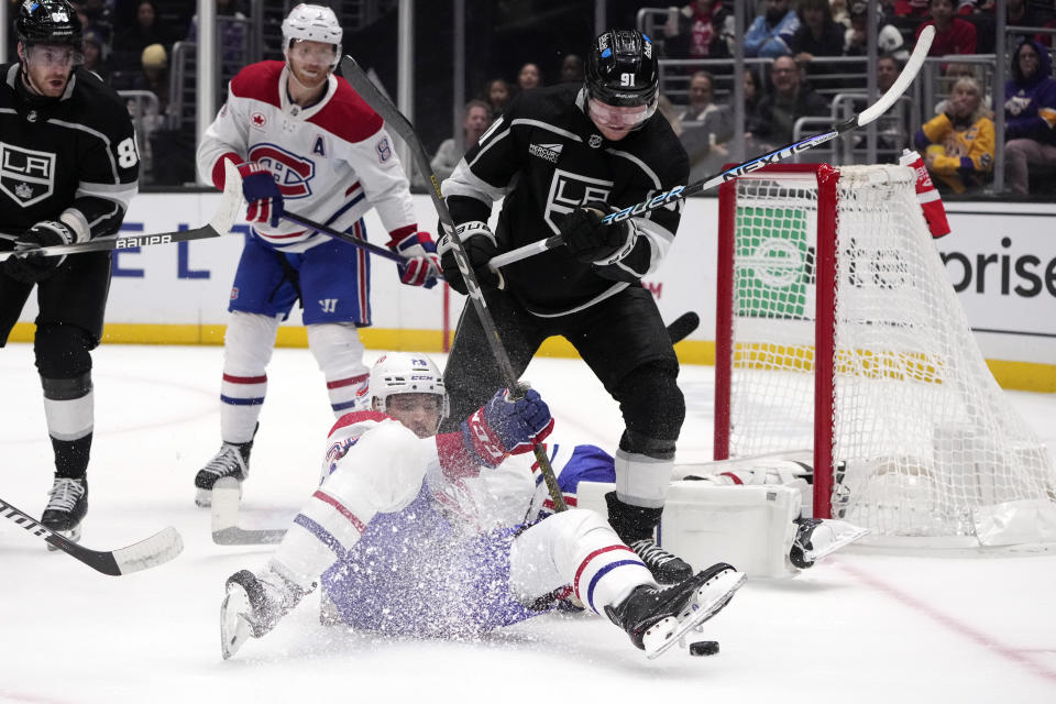Los Angeles Kings right wing Carl Grundstrom, top, works against Montreal Canadiens defenseman Johnathan Kovacevic, bottom, during the second period of an NHL hockey game Saturday, Nov. 25, 2023, in Los Angeles. (AP Photo/Marcio Jose Sanchez)