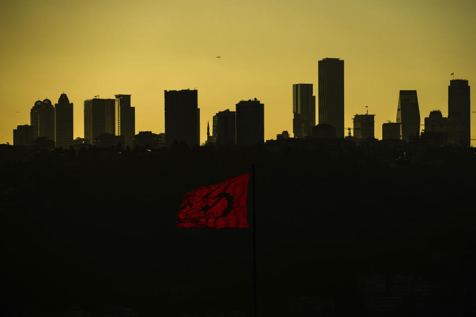 The sun sets behind high buildings of a financial business area in Istanbul, Turkey, Friday, March 22, 2024. With local elections across Turkey days away, legal experts are coaching thousands of volunteer election monitors on the rules they'll need to watch for fraud and ensure a fair vote. (AP Photo/Emrah Gurel)