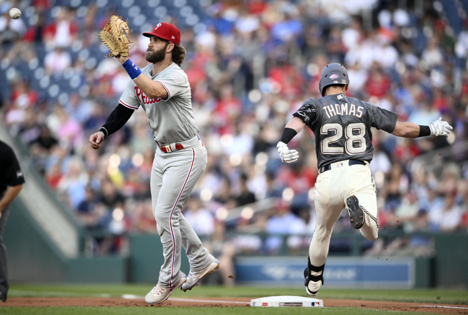 Washington Nationals' Lane Thomas (28) is safe at first with a single as Philadelphia Phillies first baseman Bryce Harper, left, waits for the ball during the first inning of a baseball game, Friday, Aug. 18, 2023, in Washington. (AP Photo/Nick Wass)
