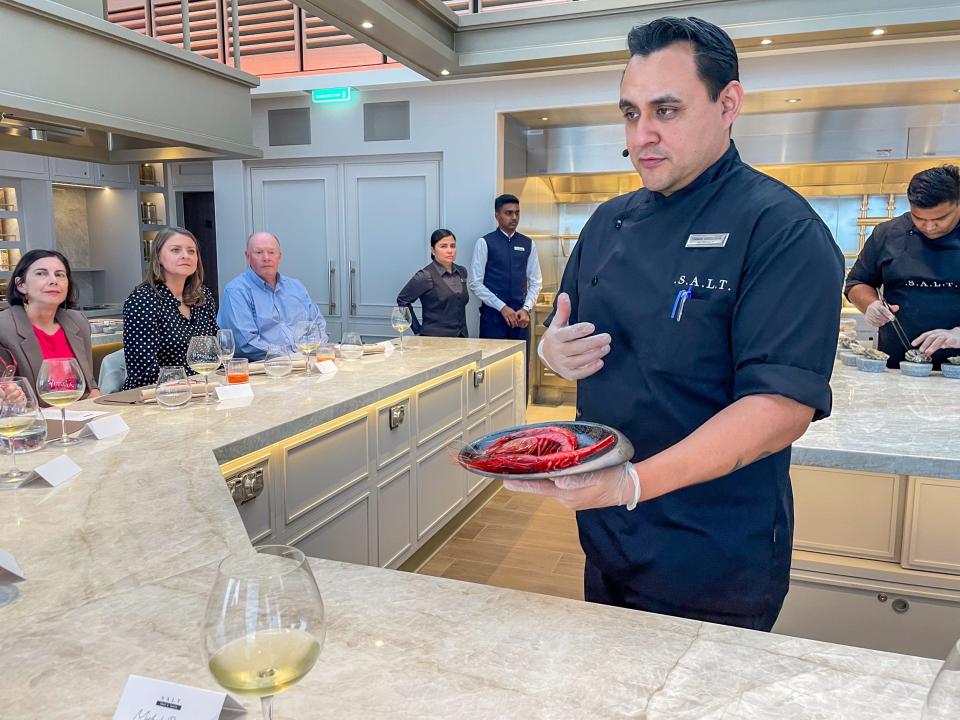 chef holding shrimp talking to guest at Chef's Table on Silver Ray