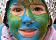 Seven years old Arvid had the globe painted on his face as he attends a climate protest of the 'Fridays for Future' movement in Berlin, Germany, Friday, Oct. 22, 2021. (Britta Pedersen/dpa via AP)