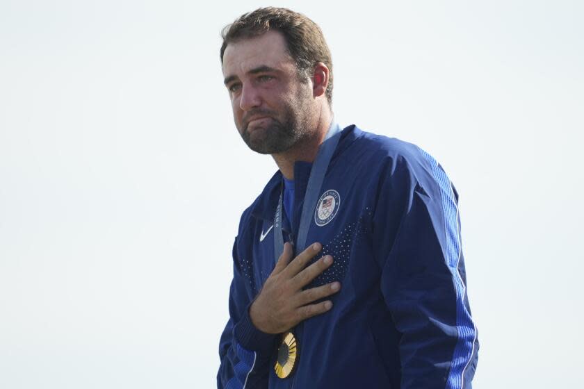 Gold medalist Scottie Scheffler cries as the U.S. national anthem is played during the Olympic medal ceremony