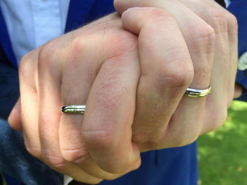 The two men show off their rings at their wedding, which is not officially recognised by the Church of England