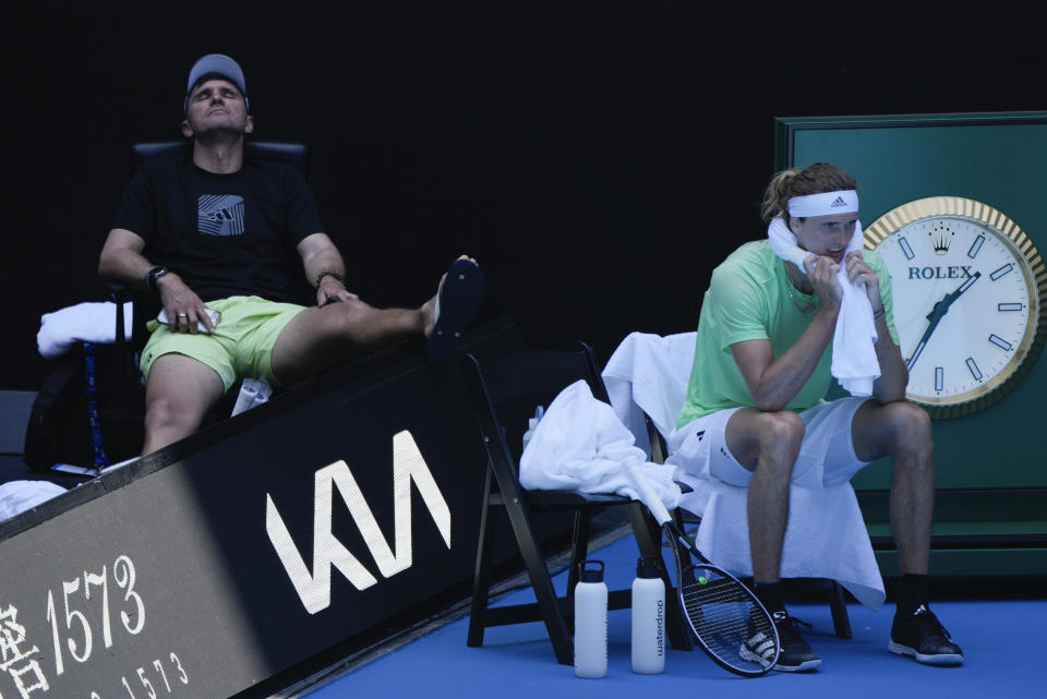 Germany's Alexander Zverev, right, rests during a practice session ahead of the Australian Open tennis championships at Melbourne Park, Melbourne, Australia, Friday, Jan. 12, 2024. (AP Photo/Andy Wong)