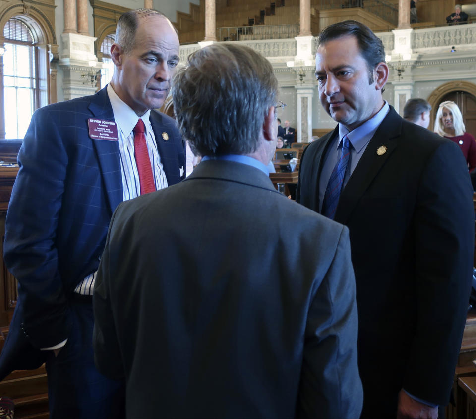 Kansas House Taxation Committee Chairman Steven Johnson, left, R-Assaria, and Appropriations Committee Chairman Troy Waymaster, right, R-Bunker Hill, talk to Rep. Jene Vickrey, R-Louisburg, during a break in the House's session, Saturday, May 4, 2019, at the Statehouse in Topeka, Kan. The Legislature's Republican leaders were trying to break an impasse over the budget and Medicaid expansion. (AP Photo/John Hanna)