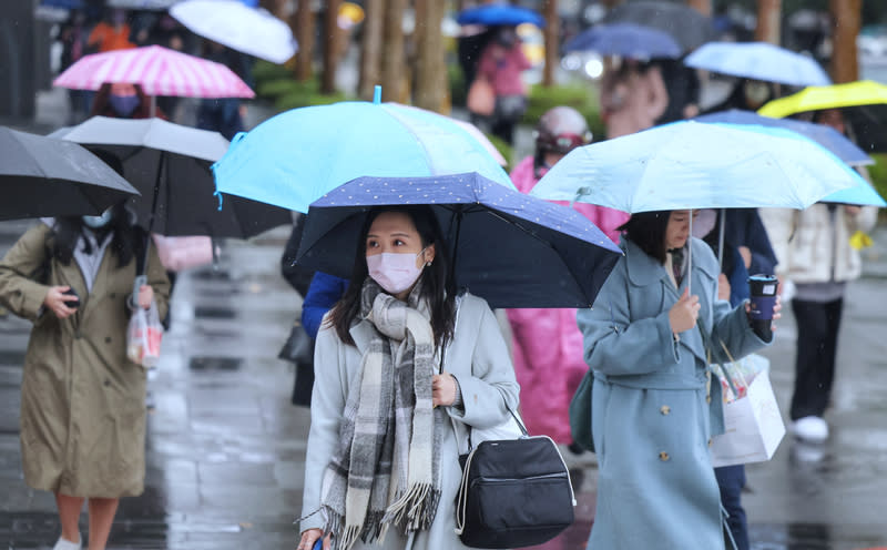 東北風影響，再冷一天！中央氣象署天氣預報29日北部跟宜蘭會比較冷，低溫攝氏12度，其他地區則日夜溫差大，由於有水氣移入，北部、東半部明天有降雨機會。圖為台北 市內湖區通勤民眾穿戴圍巾保暖、撐傘遮擋雨勢。（中央社）