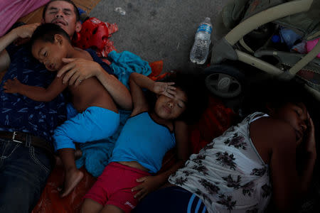 Honduran migrant Maria Reyes, 6, wakes up next to her father Alvin Reyes and mother Erly Marcial, who is eight months pregnant, and her brother David, 2, after they spent the night with fellow migrants in Tapanatepec, Mexico, November 6, 2018. REUTERS/Carlos Garcia Rawlins