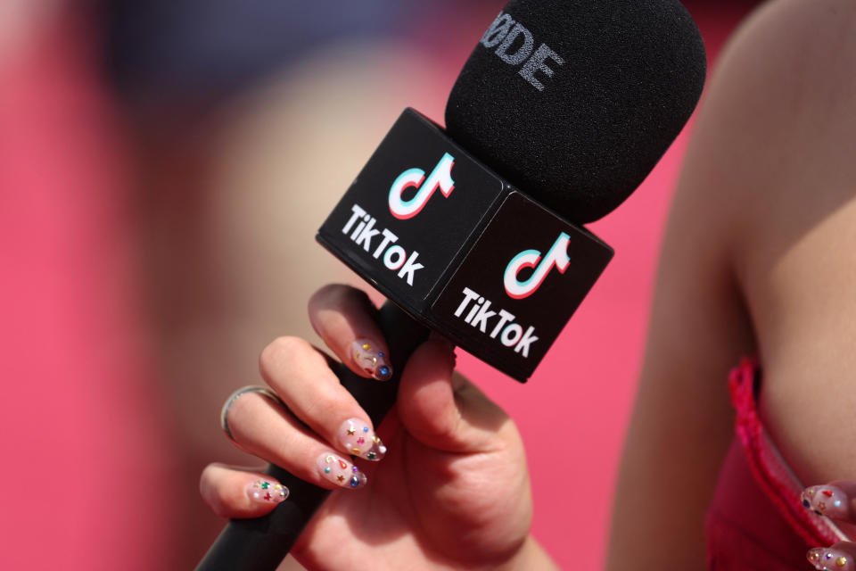 A social influencer talks into a TikTok microphone on the red carpet during the Oscars arrivals at the 94th Academy Awards in Hollywood, Los Angeles, California, U.S., March 27, 2022. REUTERS/Mike Blake