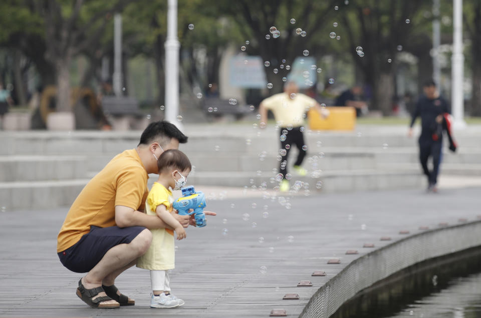 A child wearing a face mask to prevent the spread of the new coronavirus looks at soap bubbles at a park in Seoul, South Korea, Saturday, June 20, 2020. (AP Photo/Lee Jin-man)