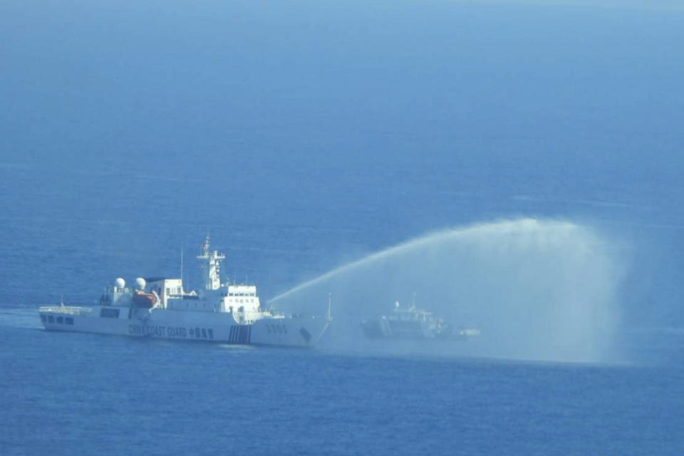 In this photo provided by the Philippine Coast Guard, a Chinese Coast Guard ship, left, uses its water cannons on a Philippine Bureau of Fisheries and Aquatic Resources (BFAR) vessel as it approaches Scarborough Shoal in the disputed South China Sea on Saturday Dec. 9, 2023. The Philippines and its treaty ally, the United States, separately condemned a high-seas assault Saturday by the Chinese coast guard and suspected militia ships that repeatedly blasted water cannons to block three Philippine fisheries vessels from a disputed shoal in the South China Sea. (Philippine Coast Guard via AP)