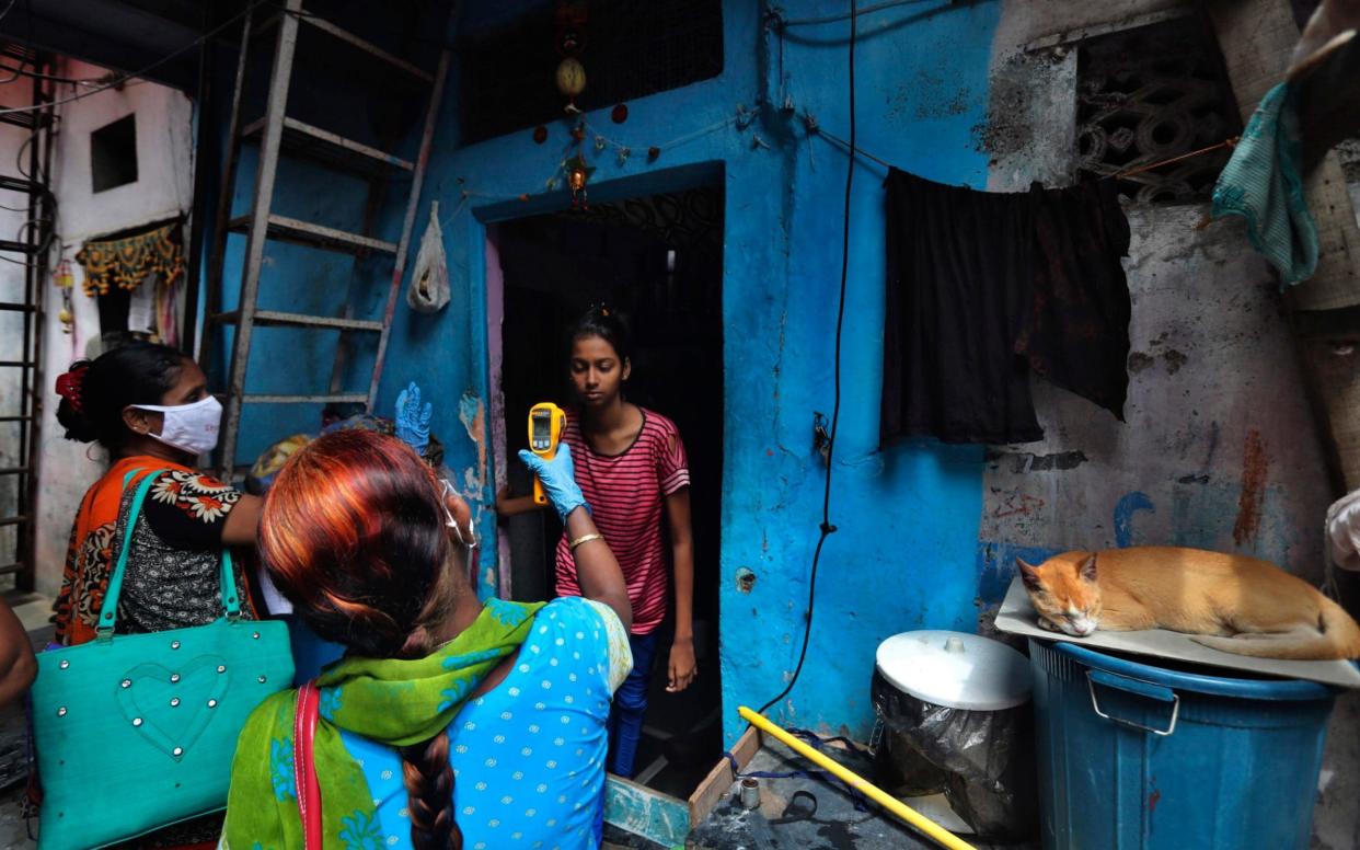 A health worker screens people for COVID-19 symptoms at Dharavi, one of Asia's biggest slums, in Mumbai - AP Photo/Rafiq Maqbool