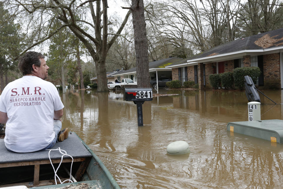 Chris Sharp studies the water damage from the Pearl River that floods his neighborhood in Jackson, Miss., Sunday, Feb. 16, 2020. Residents of Jackson braced Sunday for the possibility of catastrophic flooding in and around the Mississippi capital as the Pearl River rose precipitously after days of torrential rain. (AP Photo/Rogelio V. Solis)