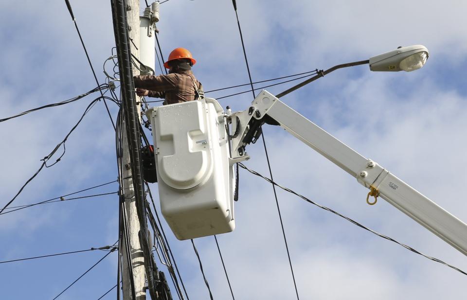 A telecommunications worker splices a fiber service terminal for a customer installation. A review of the contract Escambia County commissioners negotiated with electric utility company Escambia River Electric Cooperative to provide broadband services in the north end of the county was found to have not followed federal, state, and county regulations.