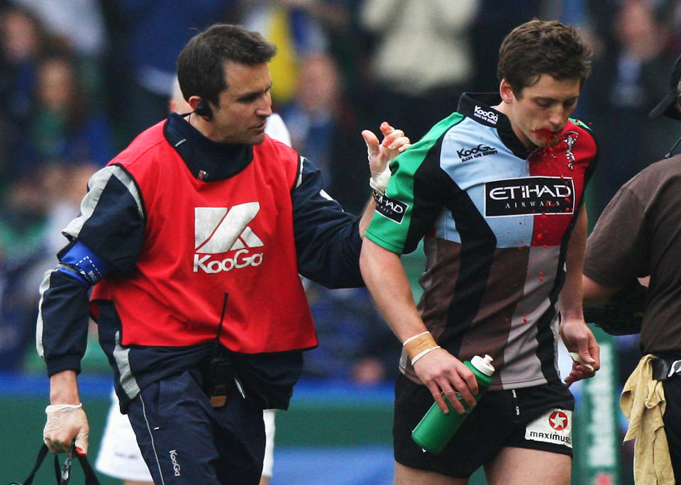 Tom Williams de los Harlequins sale del terreno de juego con el fisioterapeuta Steph Brennan para ser reemplazado por su compañero Nick Evans. (Foto: David Rogers/Getty Images)