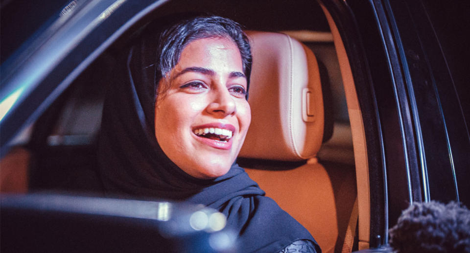 A Saudi woman poses behind the steering wheel of a car shortly after a royal decree to lift the ban on women driving took effect. Source: AAP