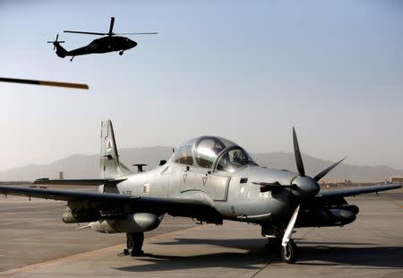 FILE PHOTO: A Blackhawk helicopter flies above a parked A-29 Super Tucano aircraft, during a handover ceremony of Blackhawk helicopters from U.S. to the Afghan forces, at the Kandahar Air base, Afghanistan October 7, 2017. REUTERS/Omar Sobhani/Files