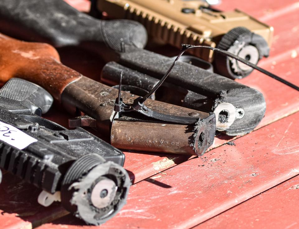 Confiscated guns by the Akron Police Department are cut apart to be made into gardening tools during the Festival of Nonviolence & Peacemaking Thursday in Akron.