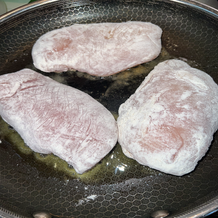 The dredged chicken placed in a pan